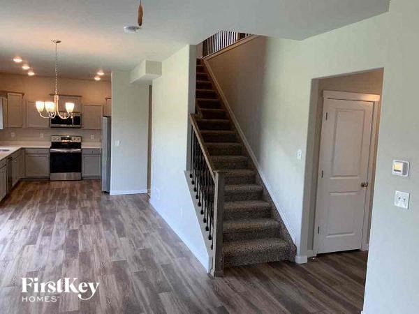 a staircase in a house with a kitchen and a door