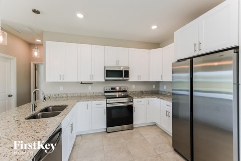 A kitchen with white cabinets and stainless steel appliances.