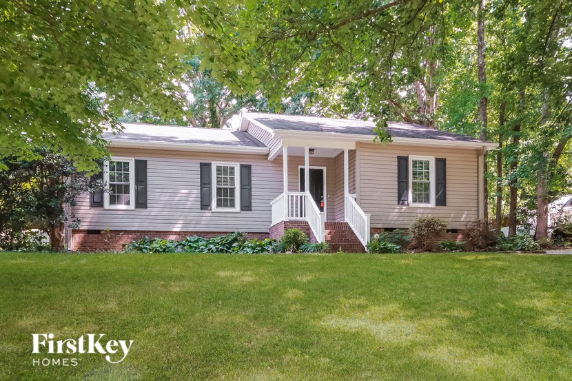 a small house with a lawn and trees