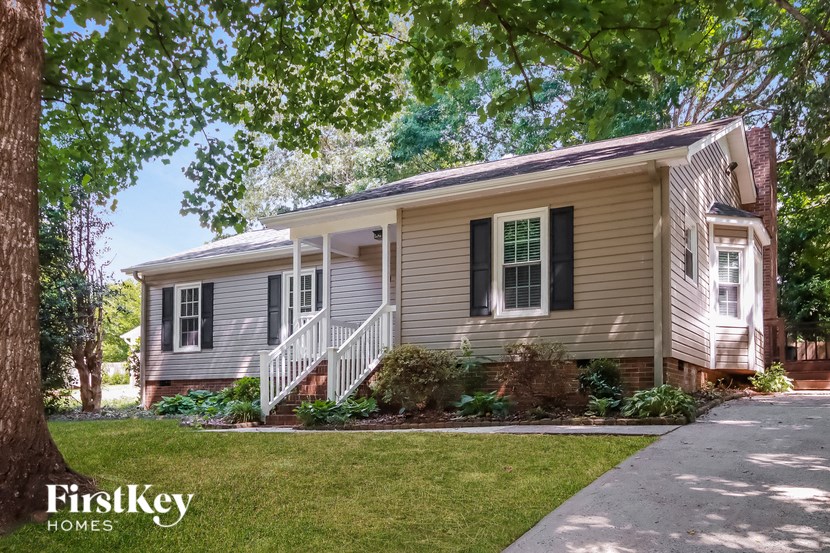 a white house with black shutters and a sidewalk