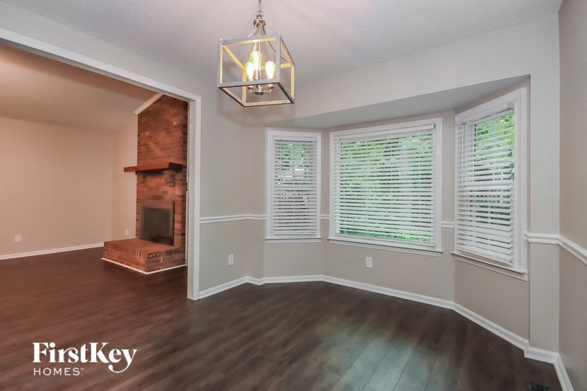 an empty living room with a fireplace and a large window