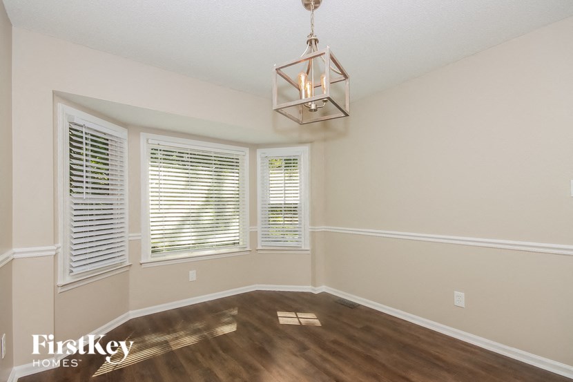 a living room with a large window and a chandelier
