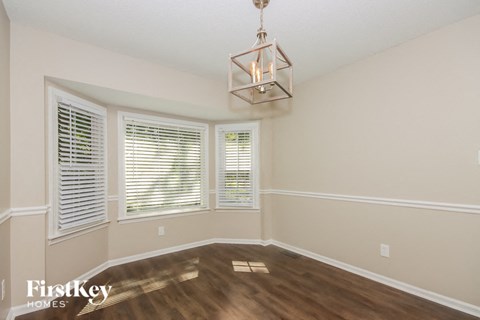 a living room with a large window and a chandelier