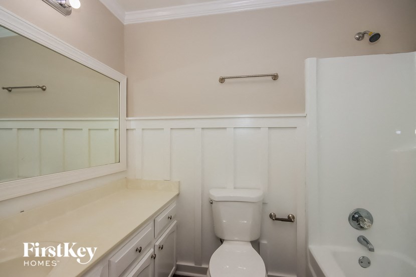 a white bathroom with a toilet and a tub and a sink
