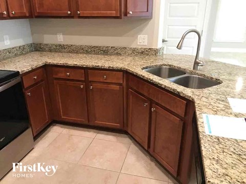 A kitchen with wooden cabinets and a granite countertop.