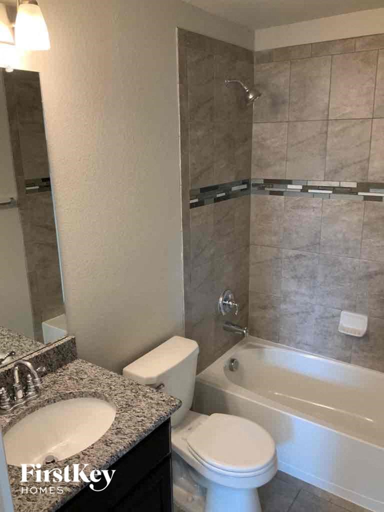 A bathroom with a toilet, sink, and bathtub.