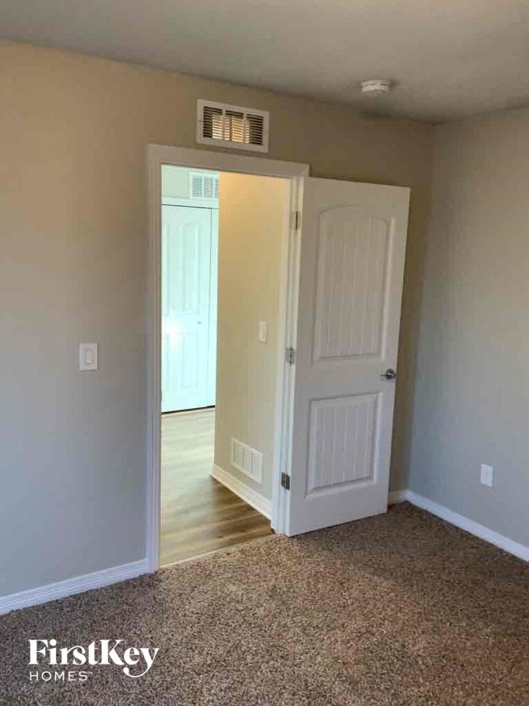 A room with a carpeted floor and a white door.