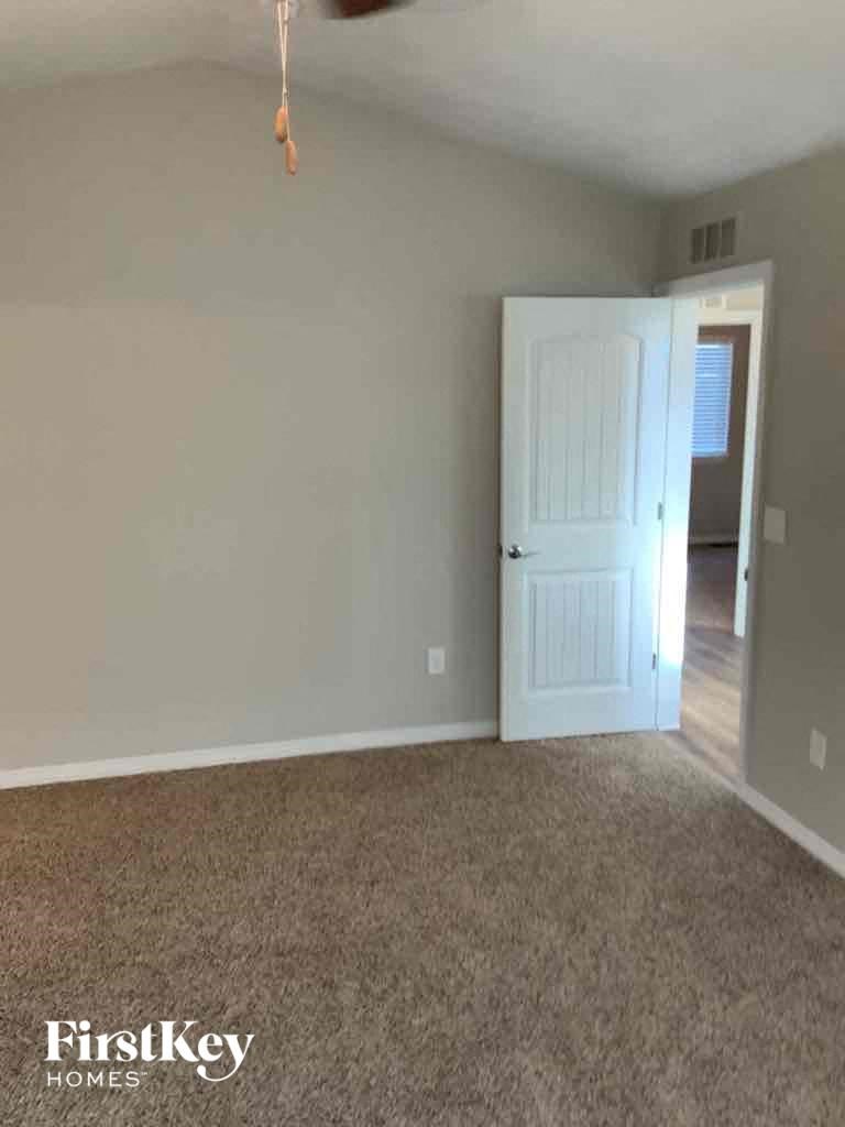 A room with a carpeted floor and a white door.