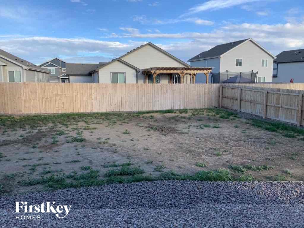 A residential area with a fence and houses in the background.