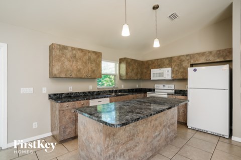 a kitchen with granite counter tops and white appliances