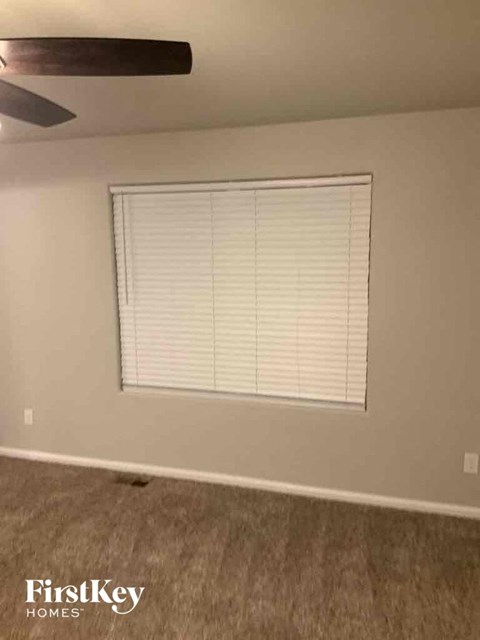 a living room with a window and a ceiling fan