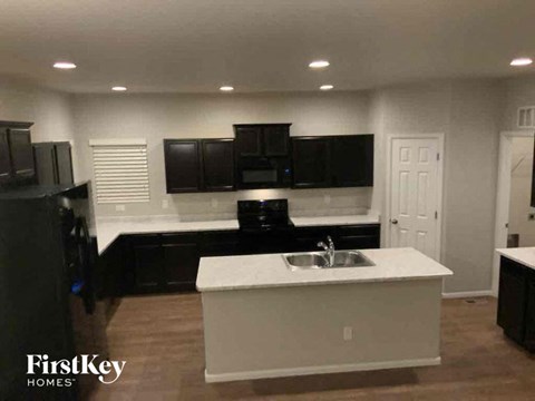 a kitchen with a sink and black cabinets