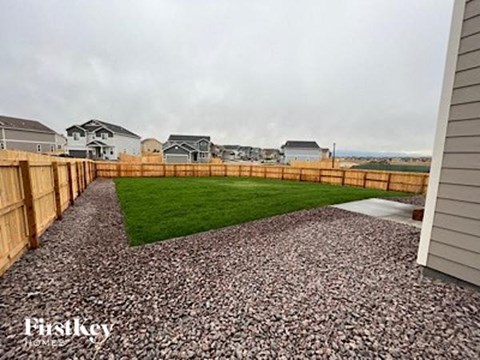 a backyard with a wooden fence and grass