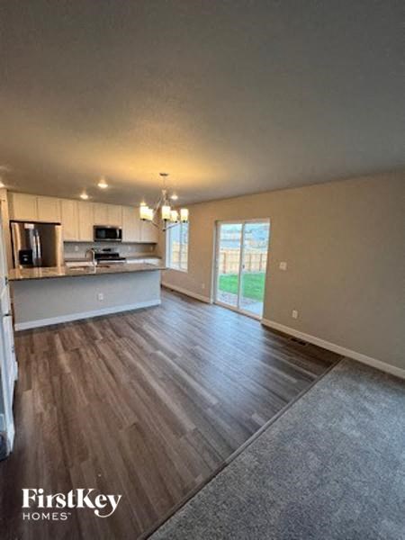 an empty living room and kitchen with wood floors