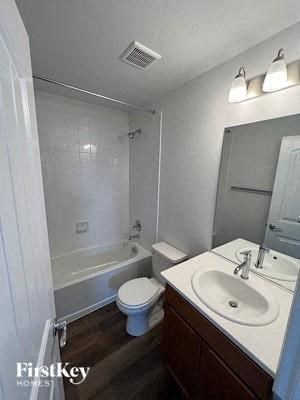 A white bathroom with a toilet, sink, and shower.