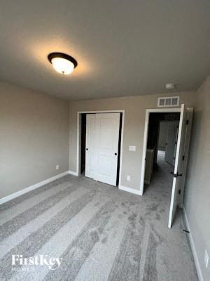 A room with a striped carpet and a white door.