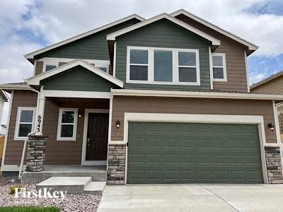 A two-story house with a garage door and a front door.
