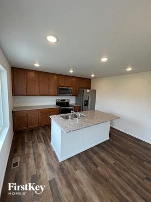 A kitchen with wooden cabinets and a granite countertop.