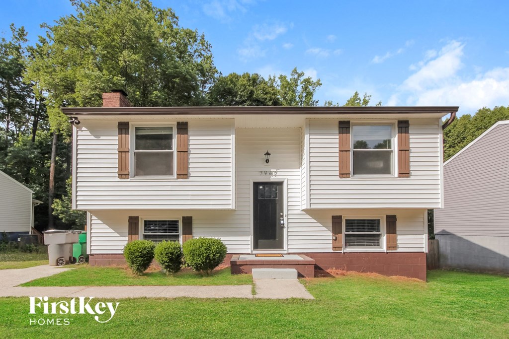 a white house with a black door and a lawn