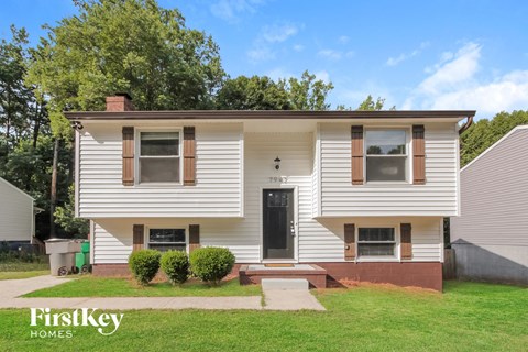 a white house with a black door and a lawn