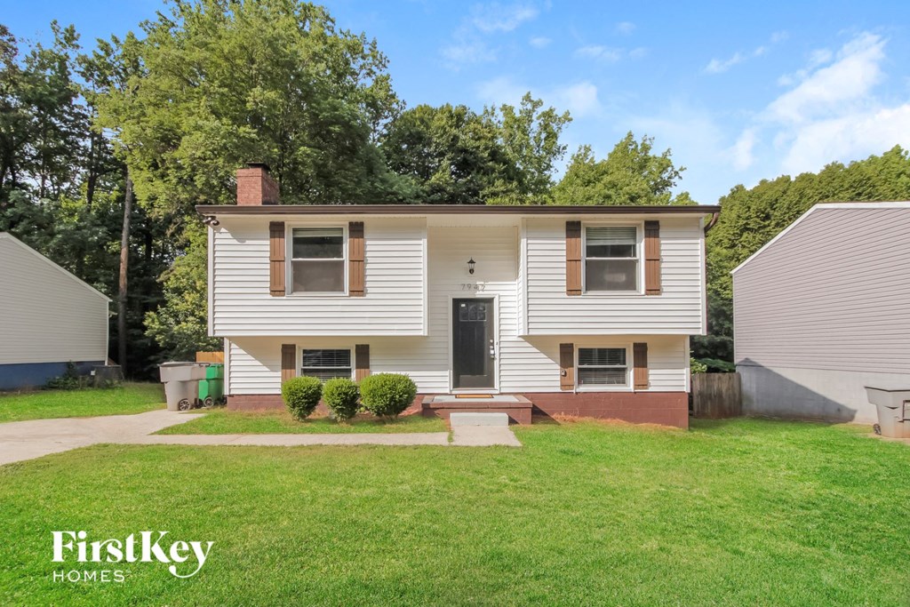 a white house with a yard and a black door