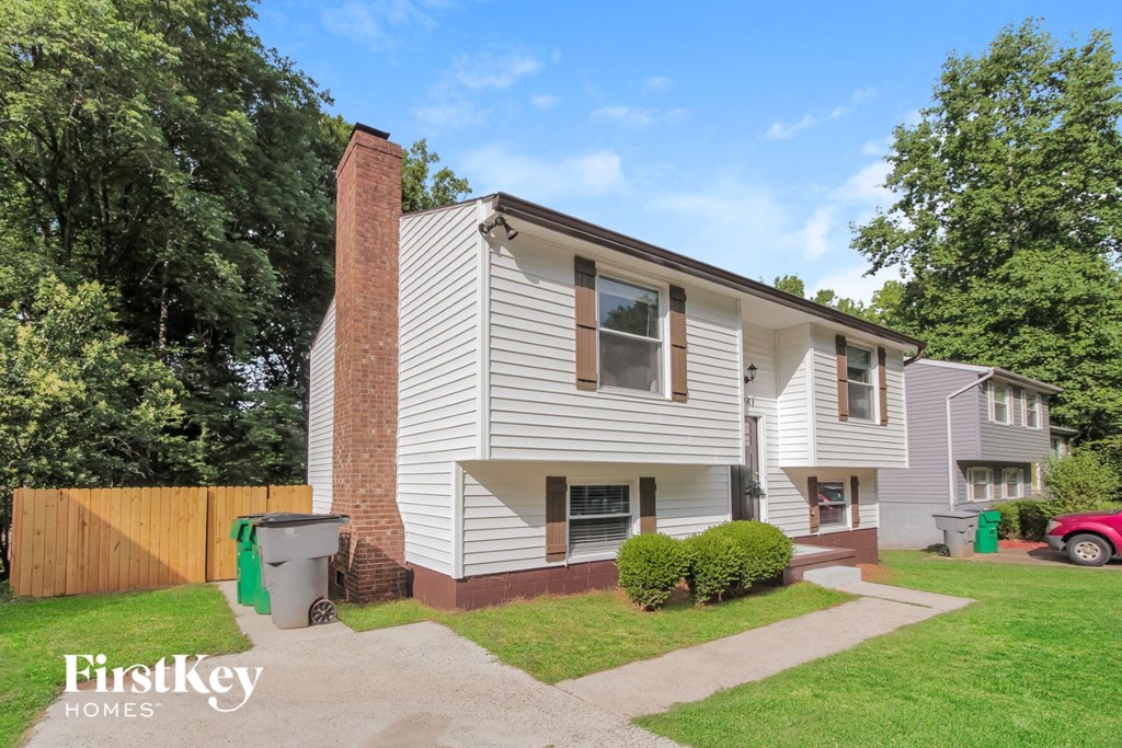 a white house with a brick chimney and a driveway