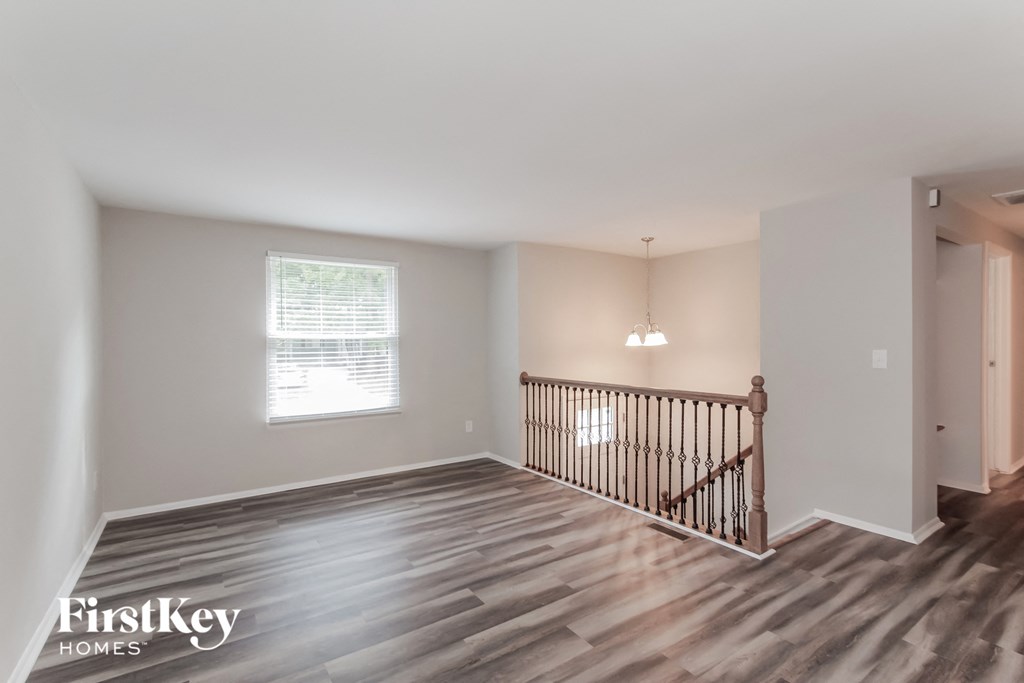 a living room with a staircase and a window