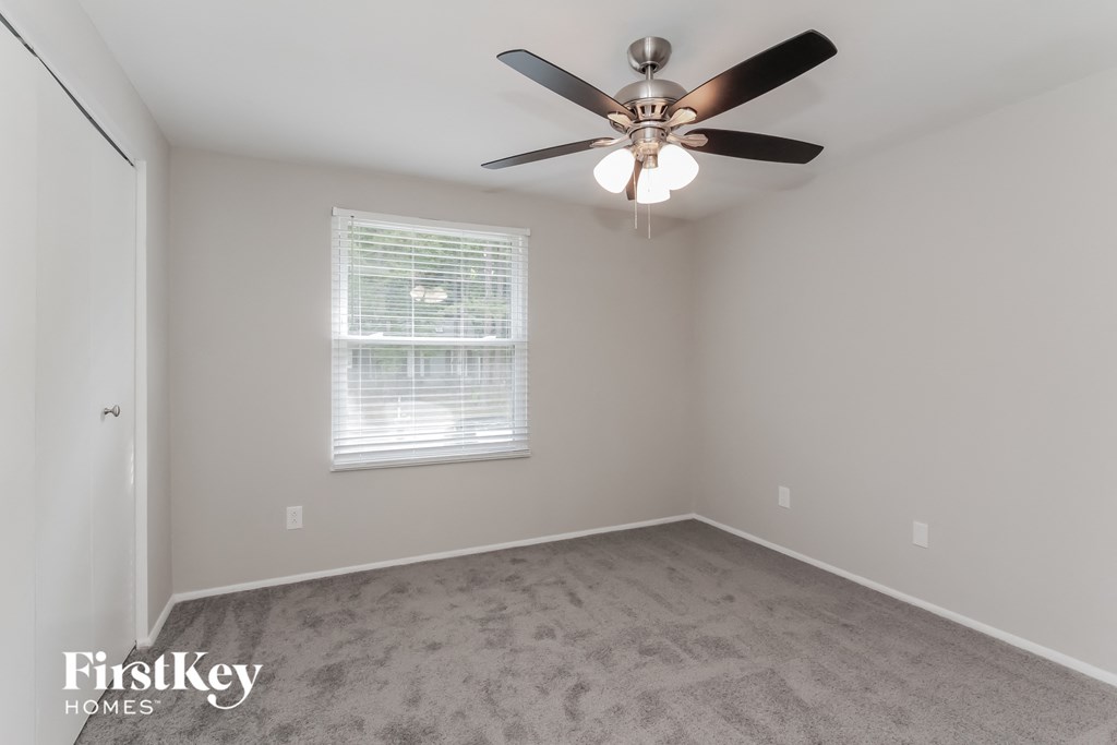 a bedroom with a ceiling fan and a window