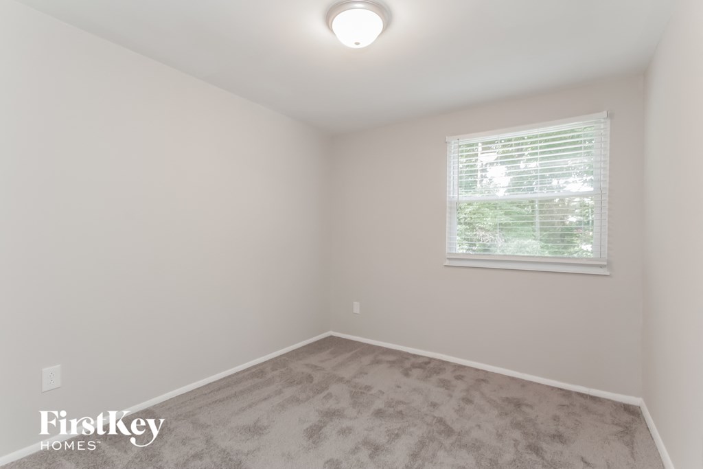 a bedroom with a carpeted floor and a window