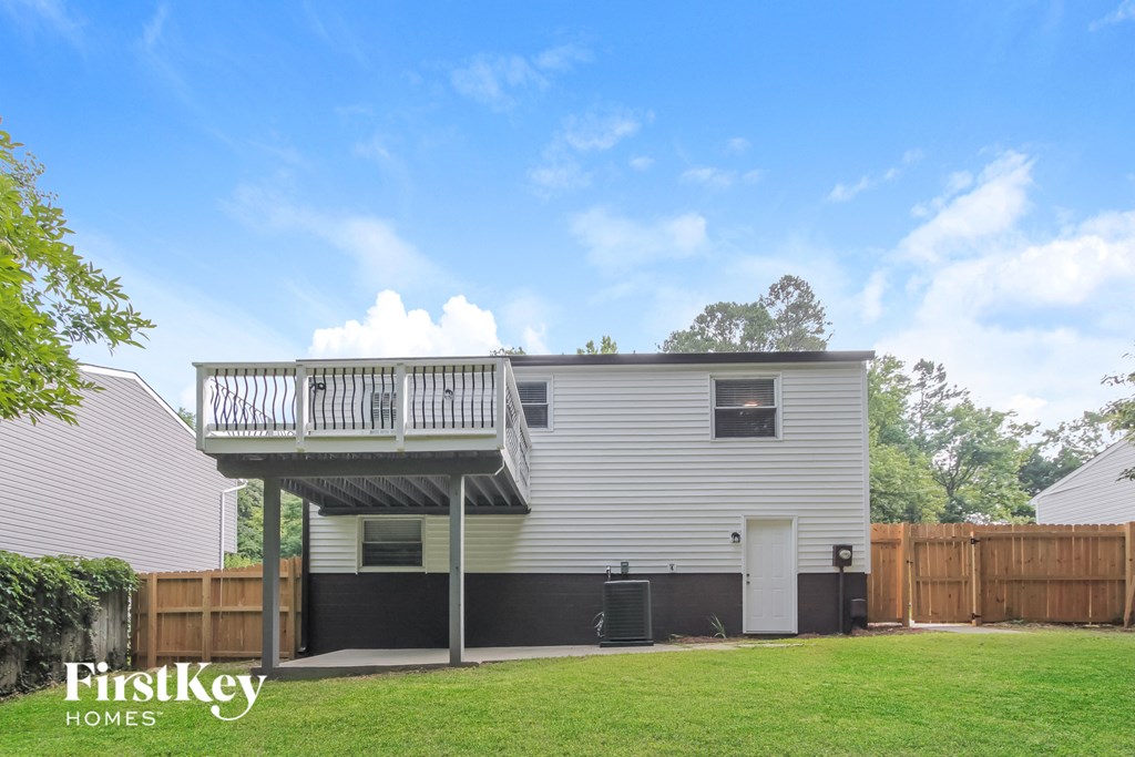 the back of a house with a deck on top of it