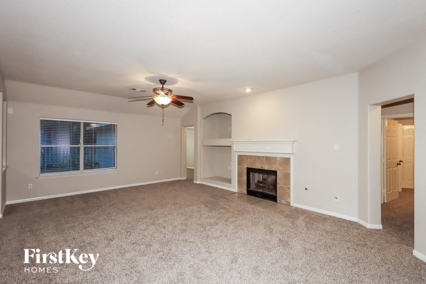 a living room with a fireplace and a ceiling fan