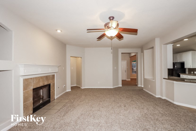 a living room with a fireplace and a ceiling fan