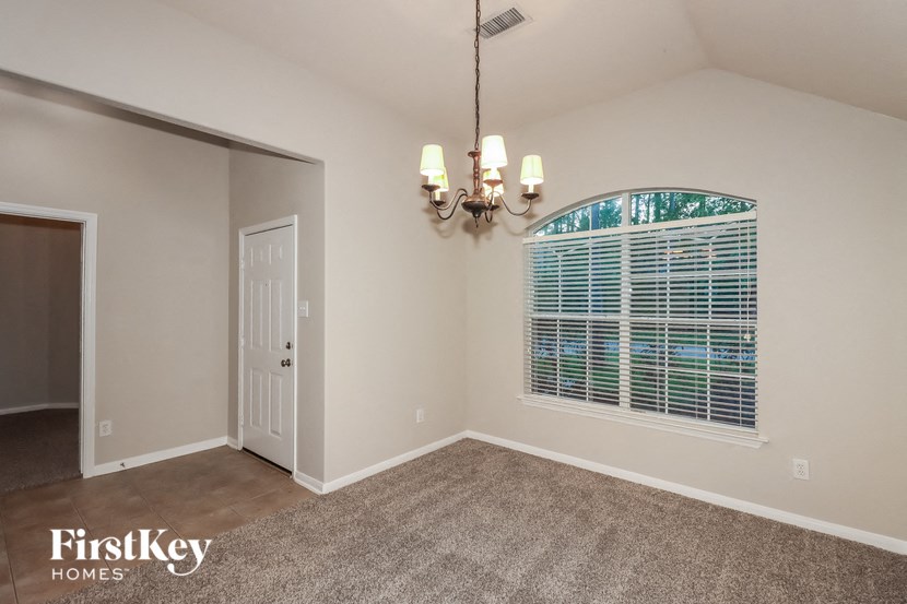an empty living room with a large window and a door