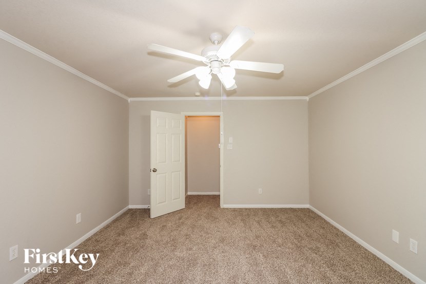 a bedroom with a ceiling fan and a closet