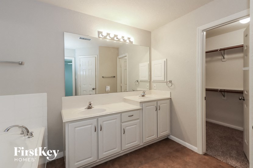 a white bathroom with two sinks and a large mirror