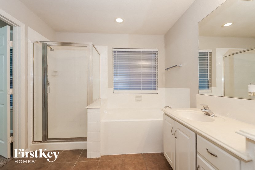 a white bathroom with a shower and a sink