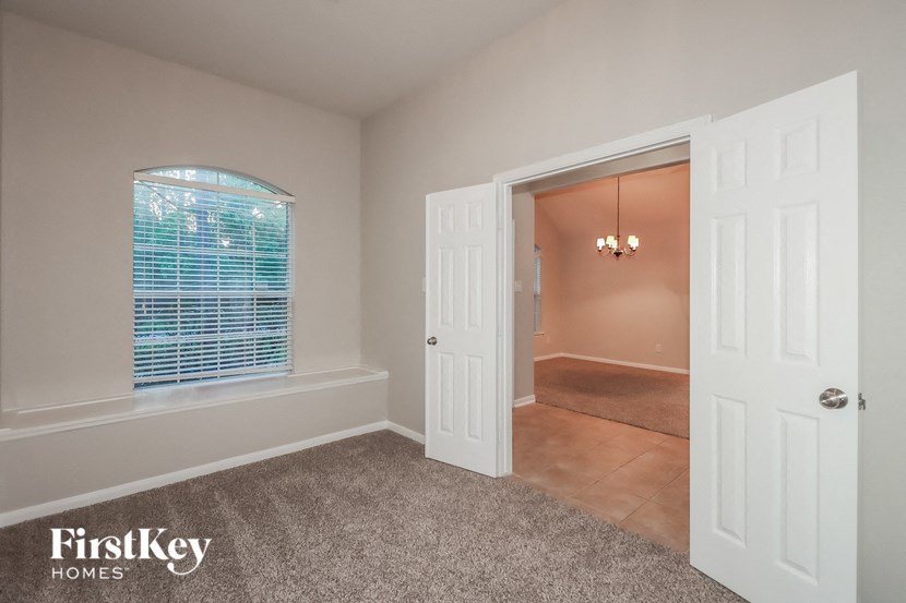 an empty bedroom with a window and a closet