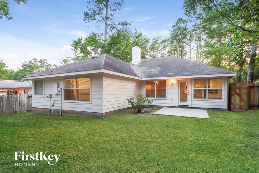 the exterior of a white house with a yard and grass