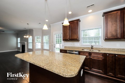 a kitchen with a marble counter top and wooden cabinets
