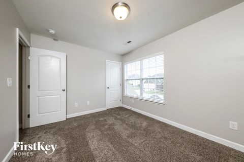 a spacious living room with carpet and a window