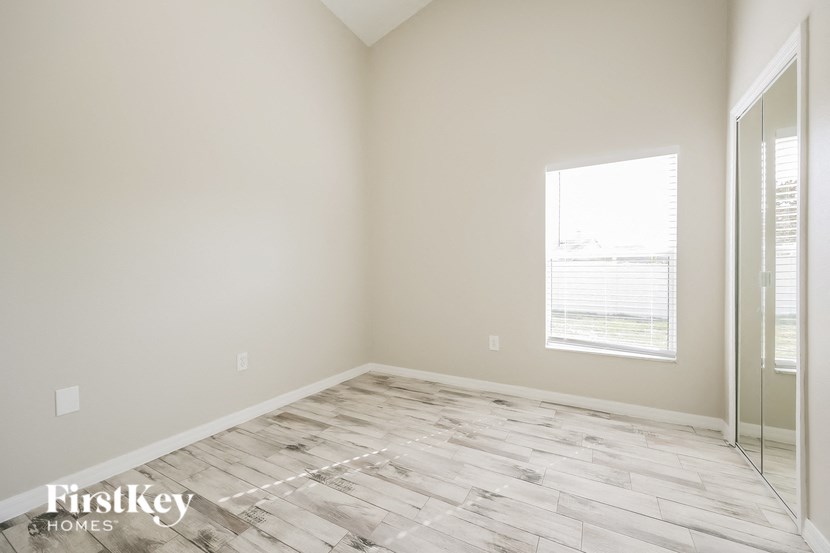 an empty room with a mirrored closet and a window