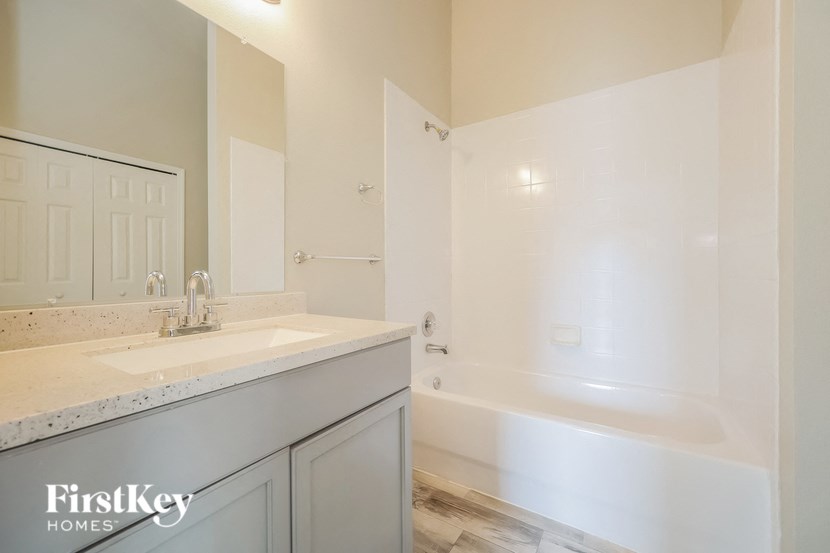 a bathroom with a sink and a tub and a mirror