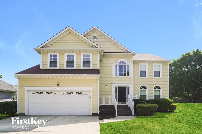 a yellow house with a white garage door