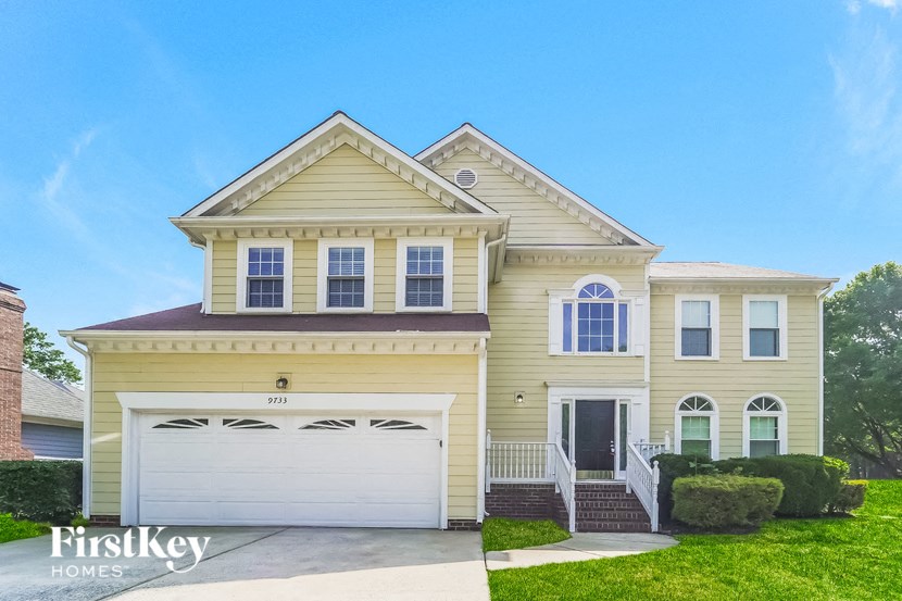a yellow house with a white garage door