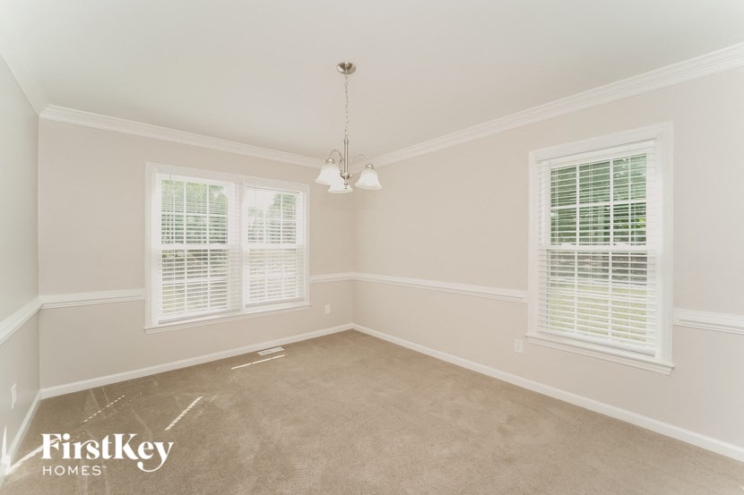 a empty room with two windows and a carpet