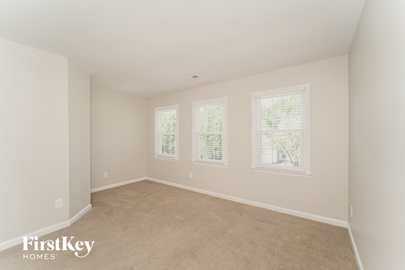 a bedroom with four windows and a carpeted floor