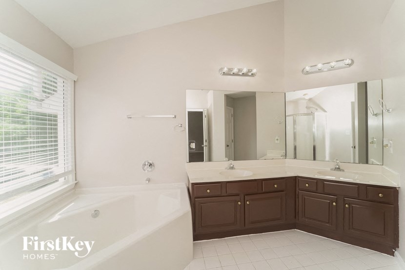 a bathroom with a tub and a sink and a mirror