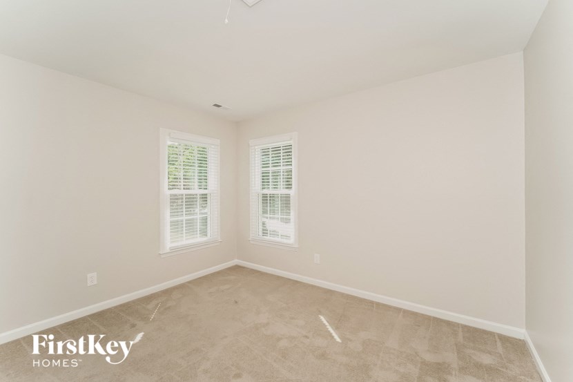 a empty room with two windows and white walls