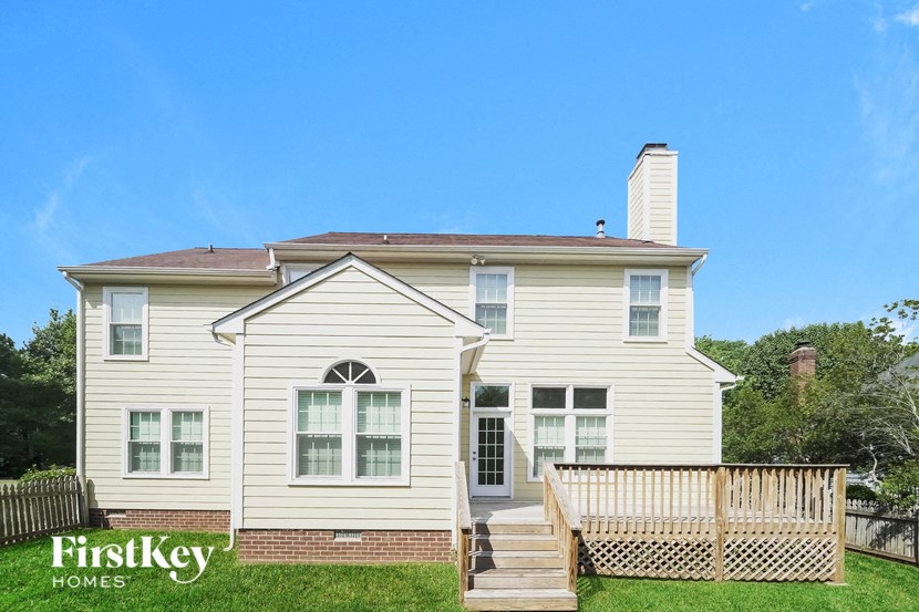 a white house with a deck and a fence