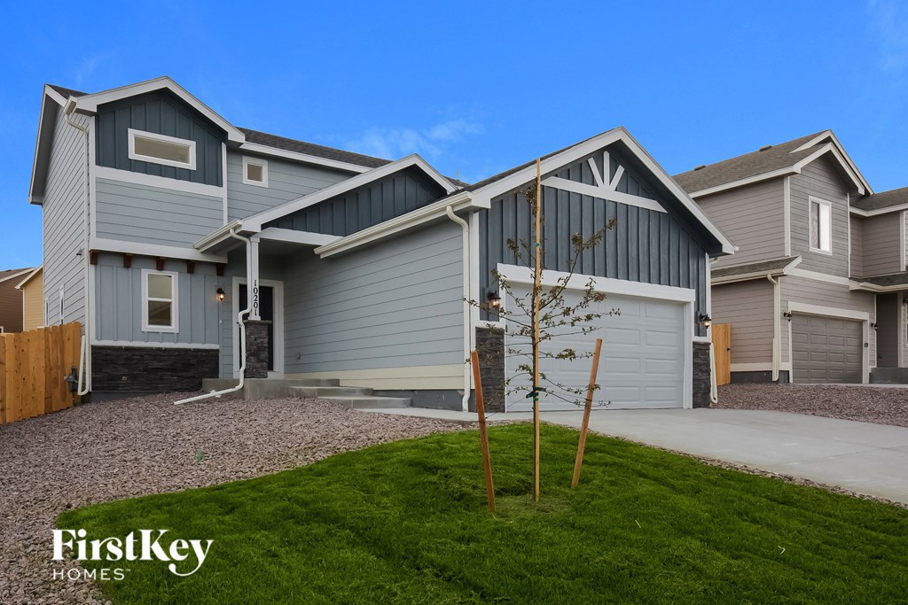 a house with gray siding and a yard with grass